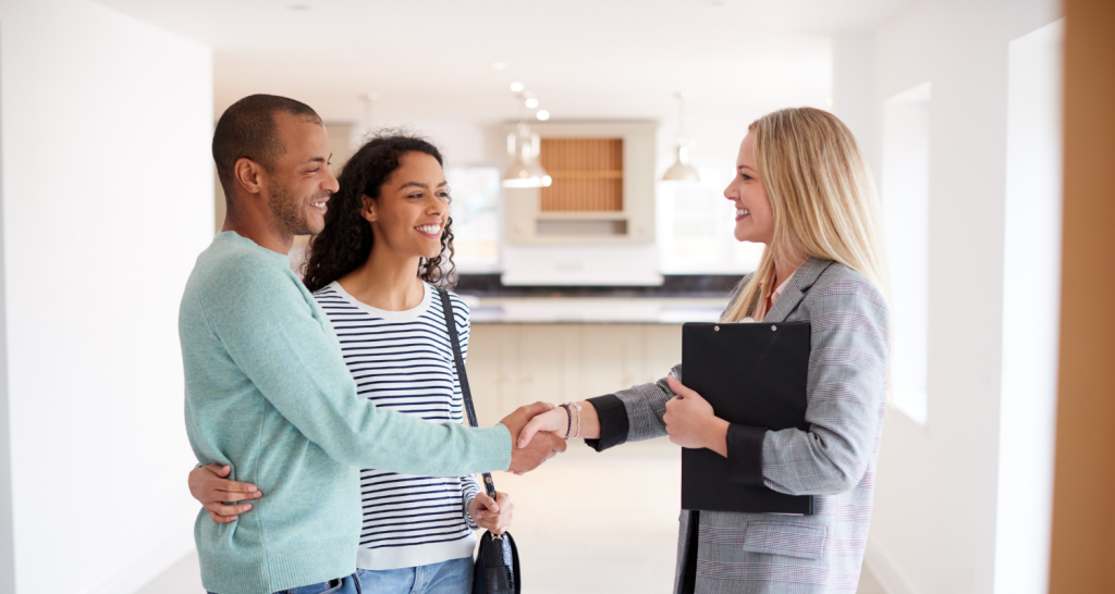 Realtor shaking hands with buyers in new home