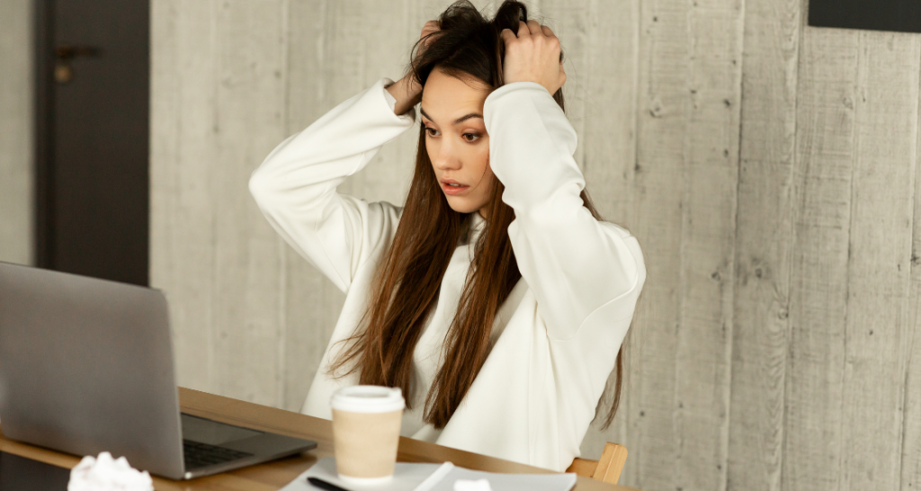 Woman frustrated looking at her computer while researching homes and purchase options.